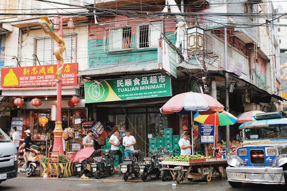 Vibrant market street in Manila's Chinatown with shops, vendors, and locals.