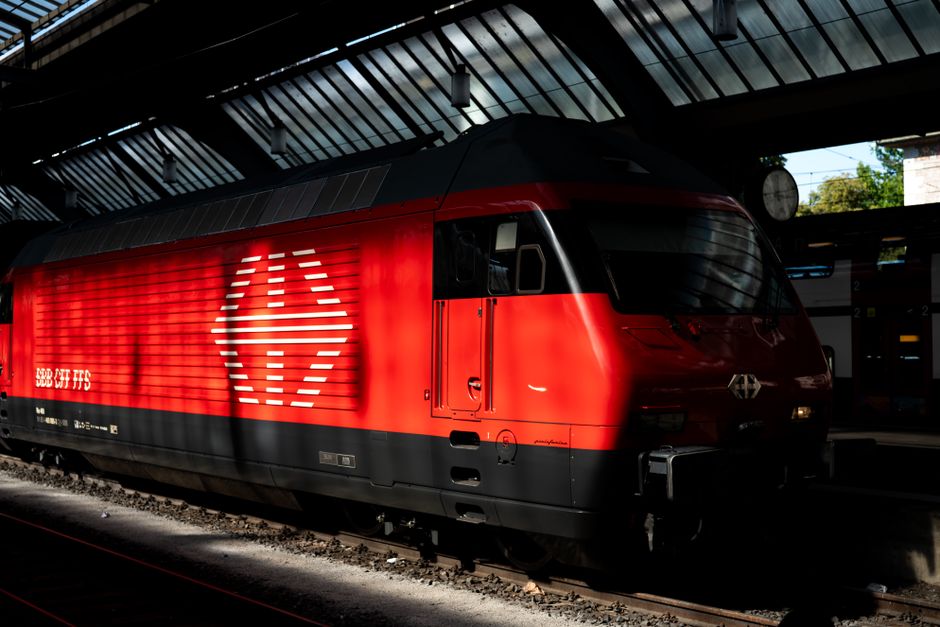 A vibrant red train at Zürich station, Switzerland captured in partial sunlight.